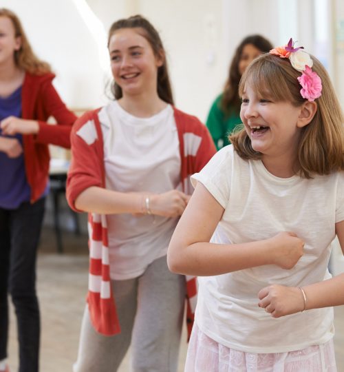 Group Of Children Enjoying Dance Lesson At Stage School Together